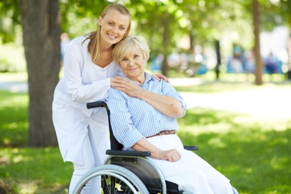 Pretty,Nurse,And,Senior,Patient,In,A,Wheelchair,Looking,At