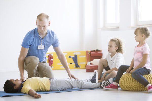 Lifesaver,Showing,Safe,Position,To,African-american,Boy,During,First,Aid